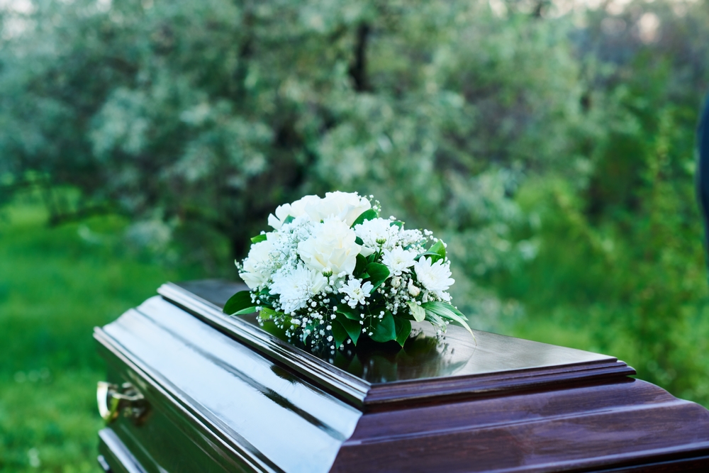 Wooden,coffin,covered,with,heavy,lid,with,bunch,of,white